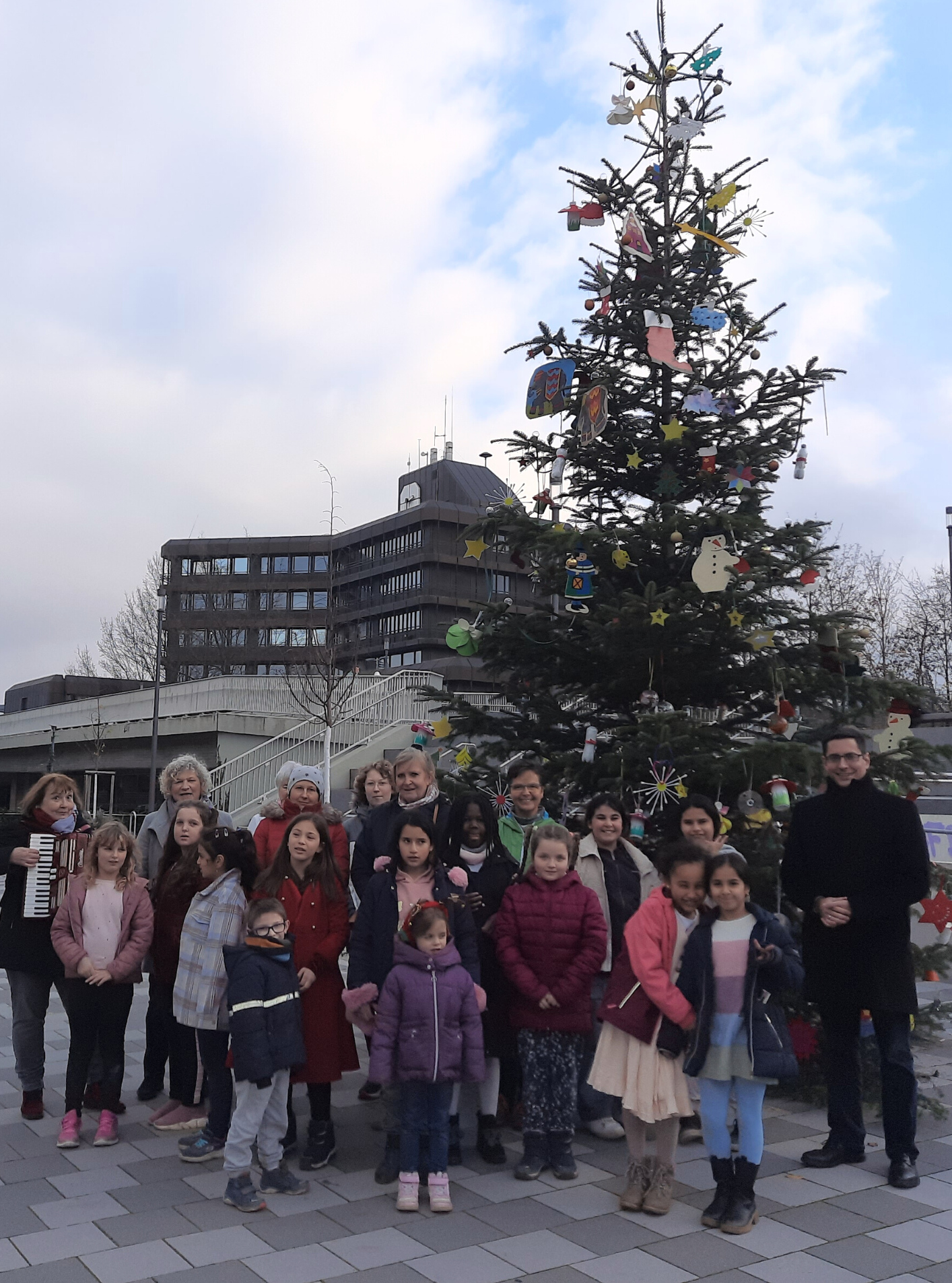 Die Kinder der KGS Mülldorf übergeben Bürgermeister Max Leitterstorf (re.) den geschmückten Weihnachtsbaum.