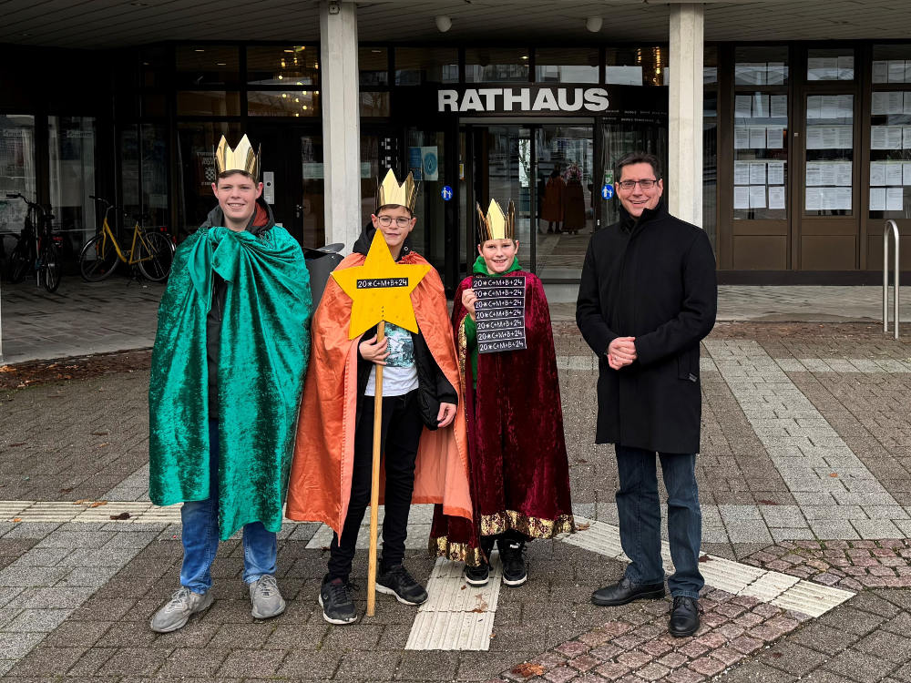 Bürgermeister Max Leitterstorf (re.) mit drei Sternsingern vor dem Rathaus.